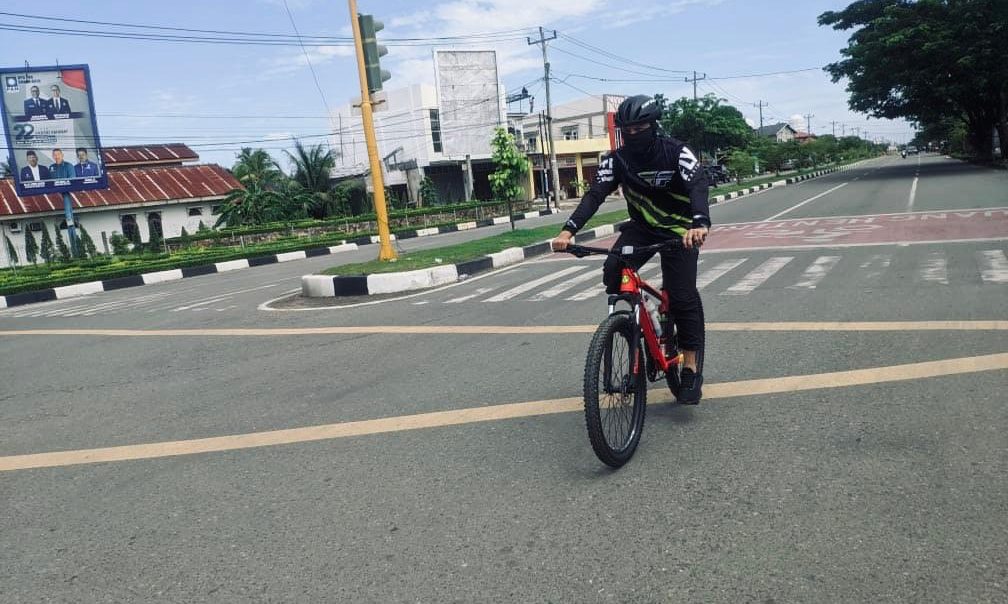 Pratama (24) Seorang pesepeda Banda Aceh sedang memanfaatkan libur weekend dengan bersepeda di jalanan yang tampak sepi.